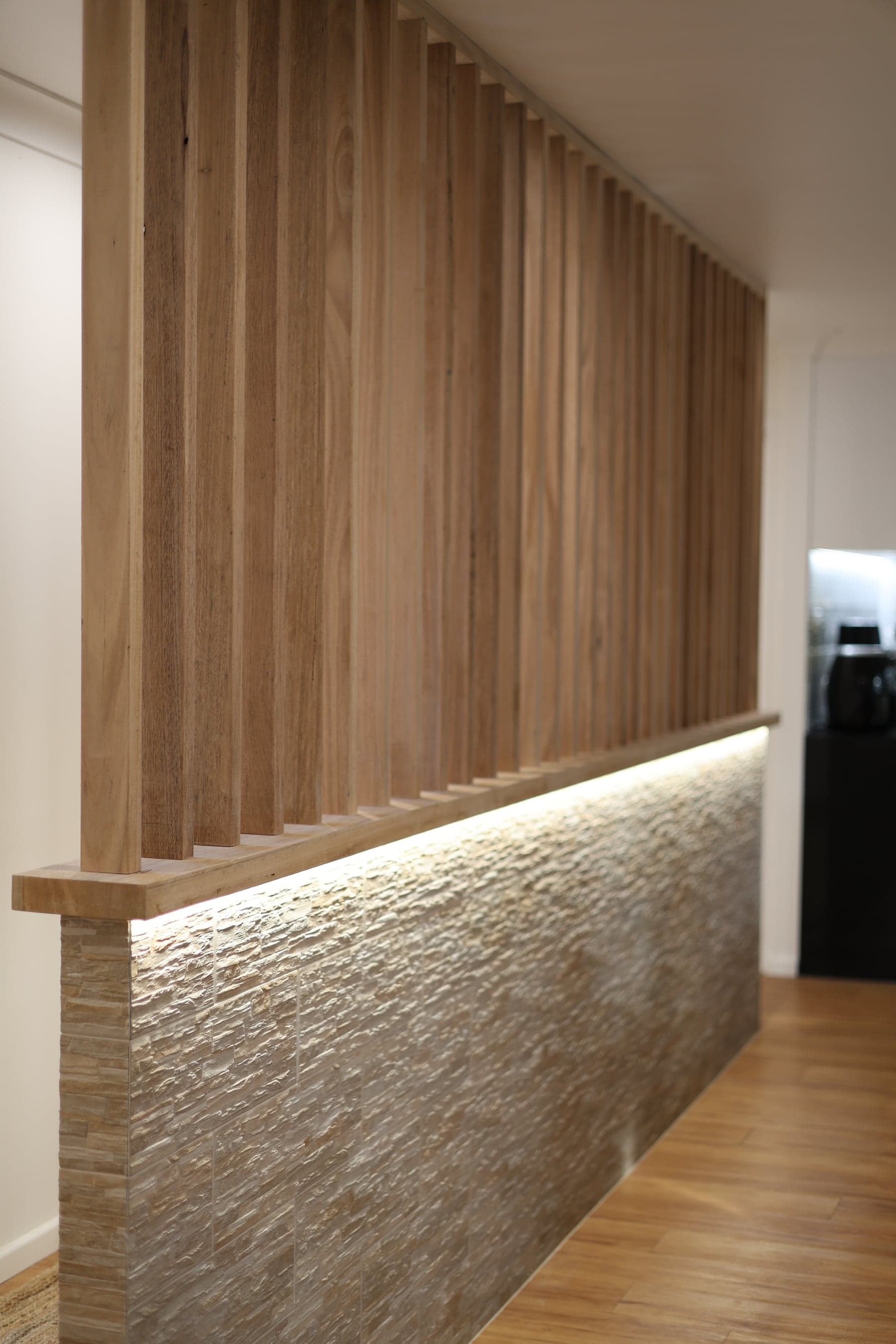 Timber batten feature wall over a stacked-stone wall