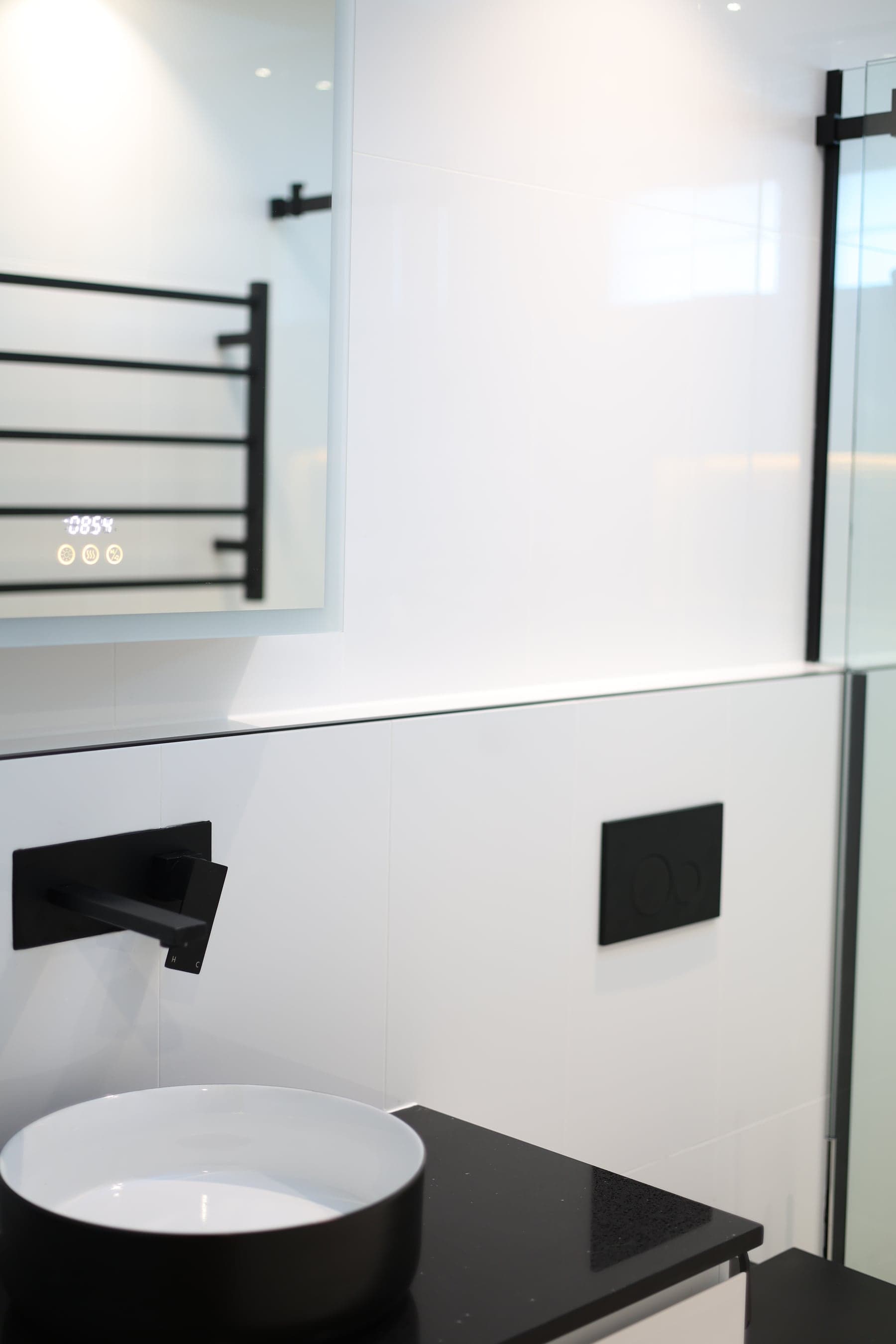Bathroom vanity with matte-black tapware and heated towel rail