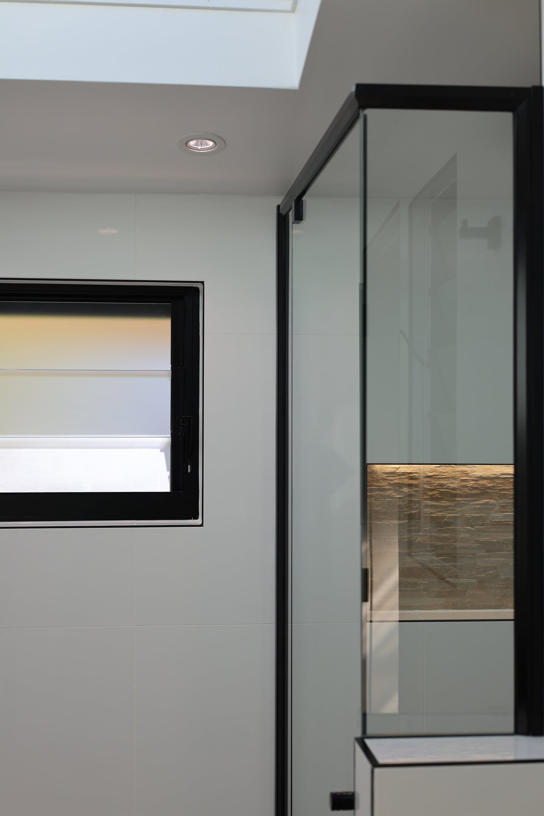 Frameless glass shower with a stone feature niche